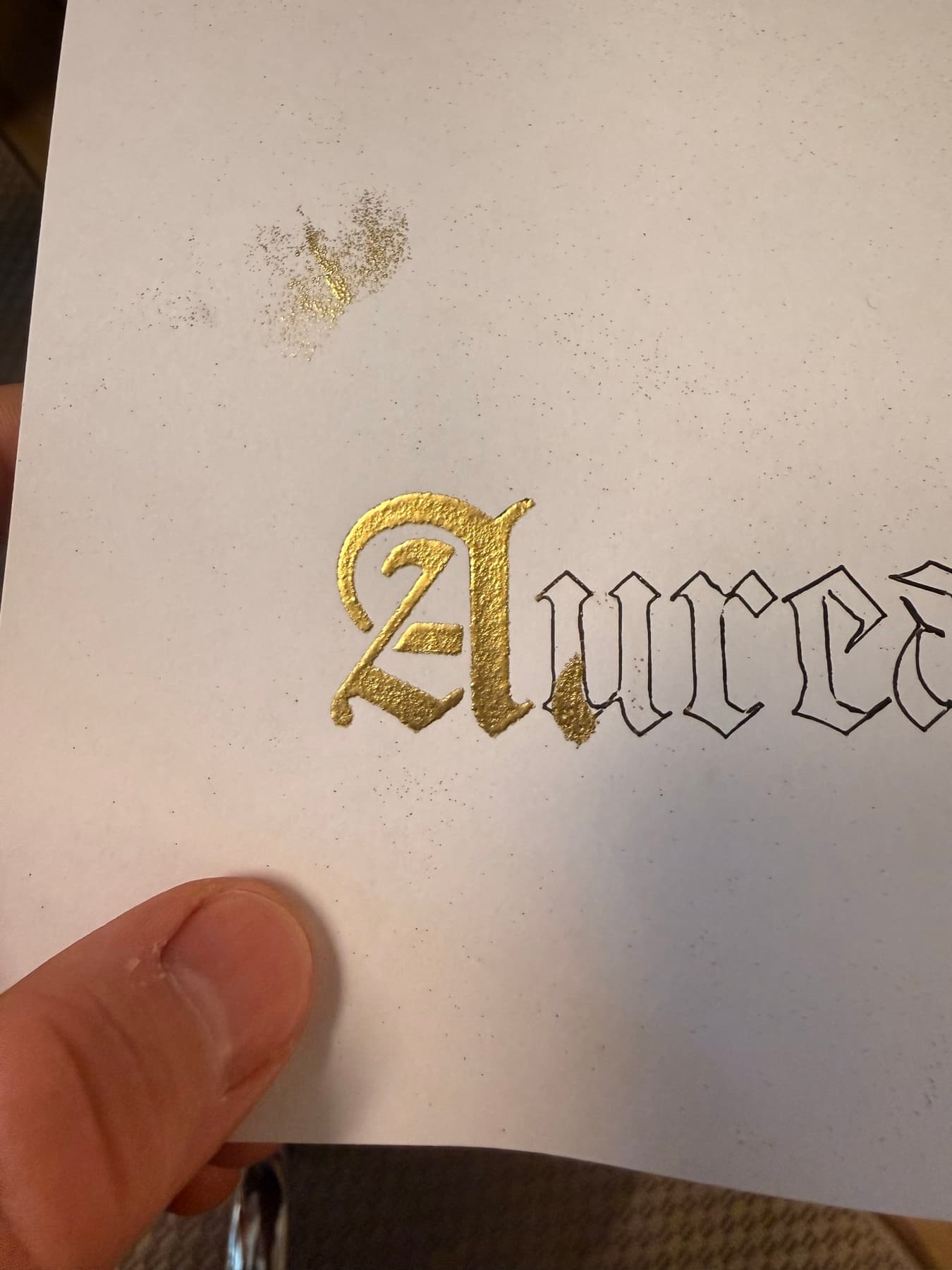 Der Schriftzug Aurea wird von Hand mit Gold ausgearbeitet.